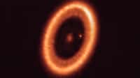 Cette image, prise avec Alma (ESO), montre le système PDS 70, situé à près de 400 années-lumière et encore en cours de formation. Le système est composé d'une étoile en son centre et d'au moins deux planètes en orbite autour d'elle, PDS 70b (non visible sur l'image) et PDS 70c, entourées d'un disque circumplanétaire (le point à droite de l'étoile). Les planètes ont creusé une cavité dans le disque circumstellaire (la structure en forme d'anneau qui domine l'image) en accrétant de la matière du disque lui-même et en augmentant leur taille. C'est au cours de ce processus que PDS 70c a acquis son propre disque circumplanétaire, qui contribue à la croissance de la planète et où des lunes peuvent se former. © Alma (ESO/NAOJ/NRAO), Benisty et al.