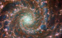 Image composite de M74, la Galaxie du Fantôme. Elle combine les observations dans le visible par Hubble et dans l'infrarouge par James-Webb. Le centre de cette magnifique galaxie spirale brille des milliards d'étoiles âgées qui y sont massées. Les étoiles les plus jeunes et chaudes (bleues), quant à elles, pullulent à travers les bras spiraux. La vue perçante de James-Webb révèle les structures souterraines (nuages sombres de gaz et de poussière) qui donnent naissance à de nouvelles génération d'étoiles. © ESA, Webb, Nasa &amp; CSA, J. Lee and the PHANGS-JWST Team; ESA/Hubble &amp; NASA, R. Chandar, J. Schmidt