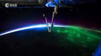 Des aurores polaires cèdent la place au lever du Soleil sous le bras robotisé Canadarm de la Station spatiale internationale. De quoi donner envie de s'installer dans l'ISS pour quelques jours de vacances contemplatives... © Esa