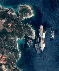 Le Costa Concordia est un paquebot de 290 m de long. L'opération pour le relever, par effet levier, est une entreprise titanesque. Ci-dessus, un montage de deux images satellite : le navire lors de l'opération de remise à flot le 17 septembre (à droite), et une vue plus large de son emplacement aux abords de la côte de l'île de Giglio en juillet 2013 (à gauche). © Astrium Geo