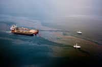 Le Mighty Servant 3, avec deux autres bateaux, en train de récolter le pétrole d'une nappe, le 18 juin 2010. Au total, environ 120 millions de litres ont été récupérés. © BP