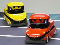 Deux RoboCar, présentées en juin 2009, montrent leurs capacités sur une route en plastique. Ici, elles posent pour la photo mais elles sont capables de rouler en suivant une ligne blanche. © ZMP / Nikkei Electronics