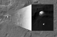 Spectaculaire photographie faite par l'orbiter MRO montrant la descente de Curiosity sous son parachute. La résolution de cette image est de 33,6 cm par pixel, ce qui permet de discerner facilement les détails du parachute comme l'intervalle entre les différentes bandes ou le trou central. © Nasa, JPL-Caltech, University of Arizona