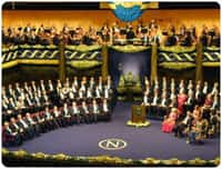 Assemblée du prix Nobel. Les nouveaux lauréats sont assis sur des chaises rouges  (à gauche) et la famille royale à droite.