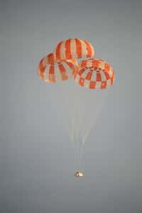 Parachutes principaux déployés, la capsule Orion-MPCV, stabilisée par un système ad hoc descend en sécurité pour se poser sans dommage sur la terre ferme. © Nasa