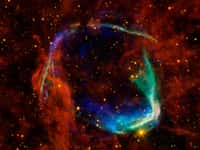 Cette image combine des données dans différentes bandes spectrales provenant de quatre télescopes spatiaux différents pour créer une vue des restes d'une supernova, appelée RCW 86, observée par les Chinois en 185. Les observations dans le domaine des rayons X de XMM-Newton (Esa) et de Chandra (Nasa) ont été combinées pour donner les détails de couleur bleu et vert. Les rayons X montrent le gaz interstellaire chauffé à des millions de degrés par le passage de l'onde de choc de la supernova. Les données infrarouges du télescope spatial Spitzer, ainsi que de Wise, sont représentées en jaune et en rouge. Elles montrent la poussière rayonnant à une température de plusieurs centaines de degrés en dessous de zéro, ce qui est plutôt chaud par comparaison à la poussière dans notre Voie lactée. © Nasa/Esa/JPL-Caltech/UCLA/CXC/SAO