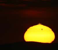 Une image qui fera date : le Soleil se lève, déformé par la diffraction atmosphérique qui torture Vénus et déclenche un fugace rayon vert. © Rico Hickmann
