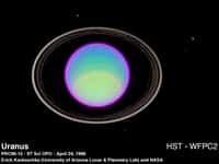 Les anneaux et quelques-uns des satellites sont visibles sur cette image d'Uranus prise en 1996 par le télescope Hubble. Crédit : E. Karkoschka / Nasa 
