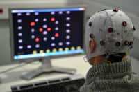 Une personne équipée d’un casque EEG essaie le jeu Brain Invaders développé par le laboratoire images parole signal automatique (GIPSA-lab) de Grenoble. © Jean-Pierre Clatot / AFP