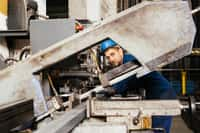 En atelier, le charpentier métallique fabrique et assemble les pièces métalliques qui seront ensuite transportées sur le chantier. Pour cela il utilise des machines à commande numérique et réalise des opérations de soudage. © Galdric, Adobe Stock.