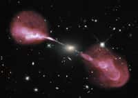 Hercules A est une galaxie elliptique située à environ 2 milliards d'années-lumière de la Voie lactée. Environ 1.000 fois plus massive que notre Galaxie, elle abrite un trou noir central de 2,5 milliards de masses solaires. On la voit dans le visible sur cette photographie prise par Hubble et sur laquelle a été surimposée une image réalisée dans le domaine des ondes radio par le VLA. Se révèlent alors deux lobes radio produits par des jets de matière relativistes, longs de plusieurs millions d’années-lumière. © Nasa, ESA, S. Baum and C. O'Dea (RIT), R. Perley and W. Cotton (NRAO/AUI/NSF), and the Hubble Heritage Team (STScI/AURA)