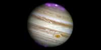 Cette illustration montre le disque de Jupiter, observé avec le HST en lumière visible et les aurores polaires en rayons x, observées avec Chandra, affichées en fausse couleurs violettes. L'émission plus intense (hot spot) au Nord apparait comme une tache plus blanche au centre de l'aurore. © rayons X : Nasa/CXC/UCL/W.Dunn et al., visible : Nasa/STScI.