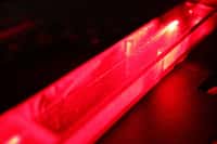 Un faisceau laser rouge (hélium néon) passe dans une microfibre optique dont le diamètre fait un micromètre. La fibre est encapsulée dans un système étanche, pour éviter qu’elle s’oxyde ou casse. © Thibaut Sylvestre, Institut Femto-ST, CNRS