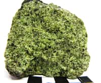 Roche grenue se composant de 40 à 90 % d'olivine, qui lui donne sa couleur verte, la lherzolite est une péridotite, vaste famille composant une grande partie du manteau supérieur terrestre. L'image montre une enclave de péridotite de type lherzolite à spinelle dans une bombe basaltique. © ENS Lyon