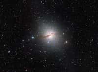 La vaste galaxie elliptique Centaurus A se situe à quelque 12 millions d'années-lumière de la Terre. Des observations effectuées avec le VLT ont permis de découvrir, autour d’elle, un nouveau type d'amas globulaires dits « sombres » (en rouge sur cette image). Les amas globulaires classiques figurent en bleu et ceux dont les propriétés sont semblables à celles des galaxies naines sont entourés d'un cercle vert. © Eso, DSS, Davide de Martin