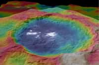 Large de 90 km, le cratère Occator doit sa célébrité aux énigmatiques taches blanches parsemées en son sein. Les couleurs correspondent aux différences d’altitude : en bleu, les plus basses et en rouge, les plus élevées. © Nasa, JPL-Caltech, UCLA, MPS, DLR, IDA