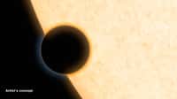 Illustration du transit de l’exo-Neptune HAT-P-11b devant son soleil. En analysant la lumière de l’étoile-hôte bloquée par l’exoplanète, les astronomes peuvent déduire la composition de son atmosphère. Si par chance, le temps est clair dans les couches supérieures de ce monde lointain, il est possible alors de détecter la présence éventuelle de molécules d’eau (partie orangée qui nimbe l’exoplanète). © Nasa, JPL-Caltech