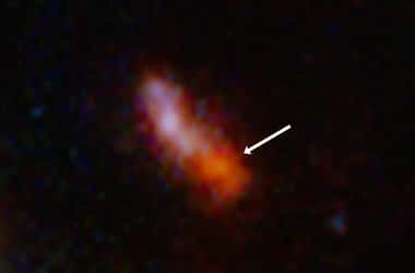 Dans le cadre se trouve une tache en forme de banane qui est bleu-rouge dans une moitié et nettement rouge dans l'autre moitié. Une flèche pointe vers la partie la plus rouge et est étiquetée « Jades GS z 14 – 0 ». C'est la galaxie la plus ancienne observée à ce jour. © Nasa, ESA, CSA, STScI, B. Robertson (UC Santa Cruz), B. Johnson (CfA), S. Tacchella (Cambridge), P. Cargile (CfA)