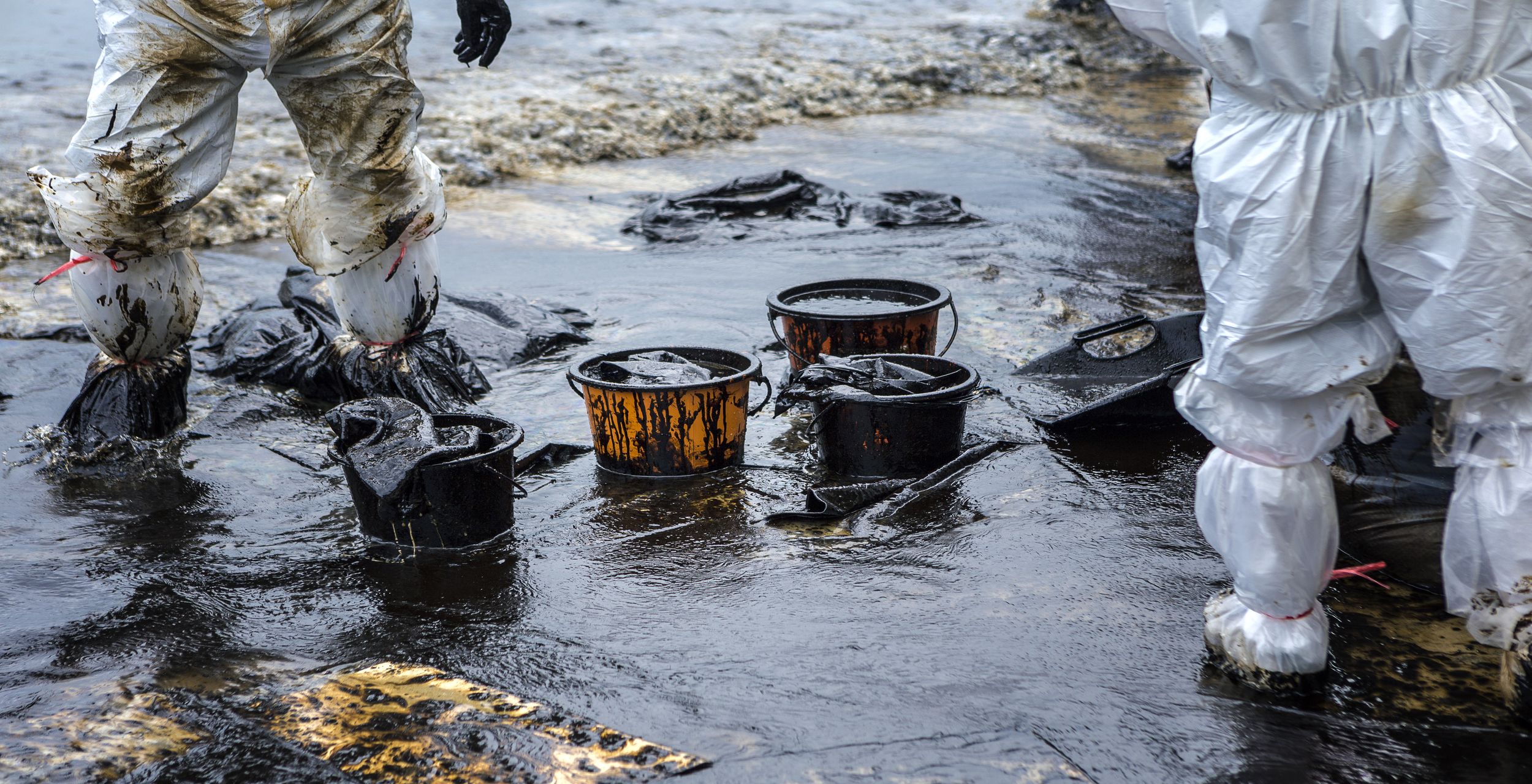 Des unités HazMat écopent le pétrole ayant submergé une plage lors d'une marée noire. © jukuraesamurai