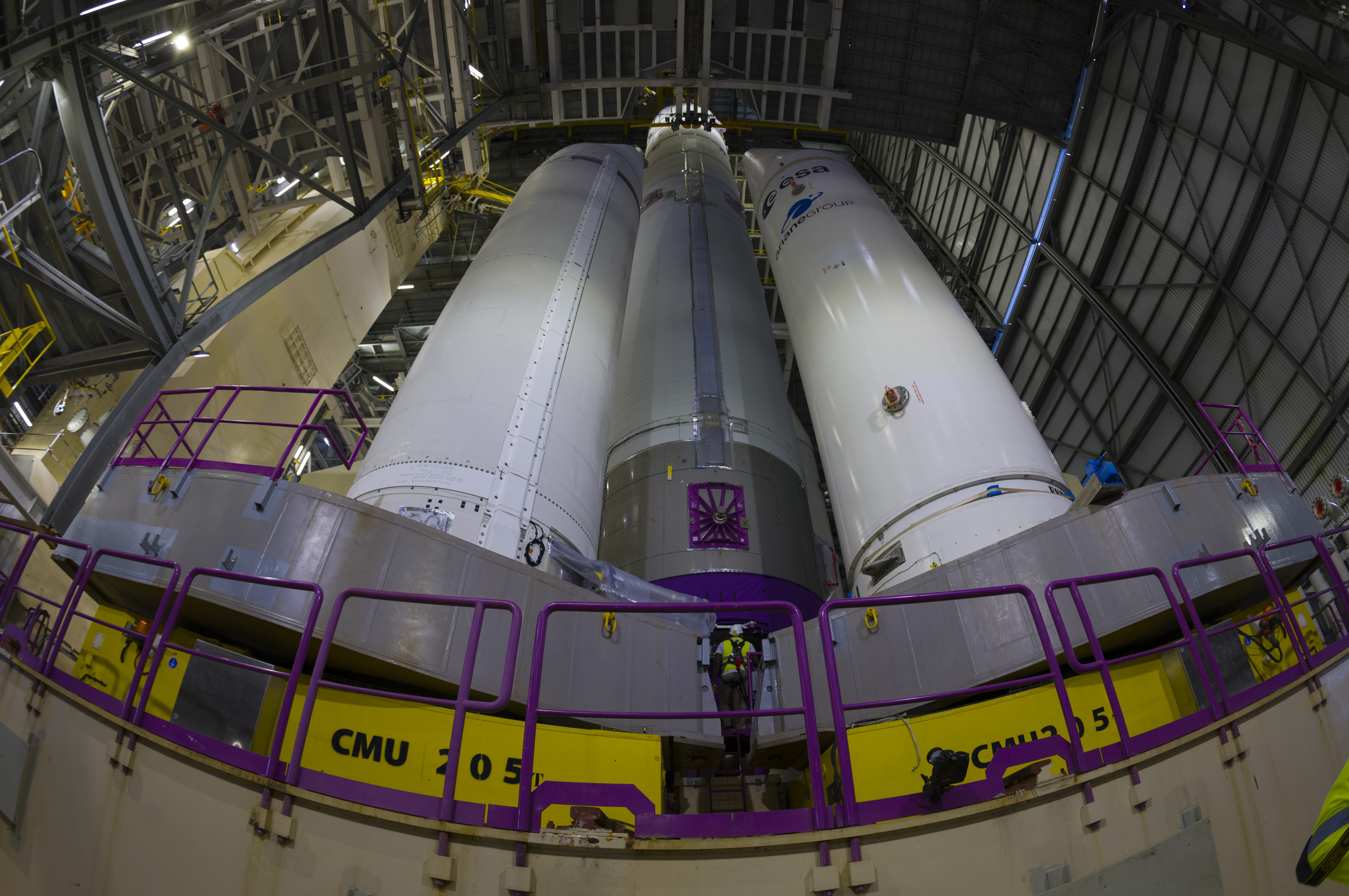 Vue en pied du corps central d'Ariane 6, verticalisé et installé sur la table de lancement, entre les maquettes de boosters.&nbsp;© ESA, Stéphane Corvaja