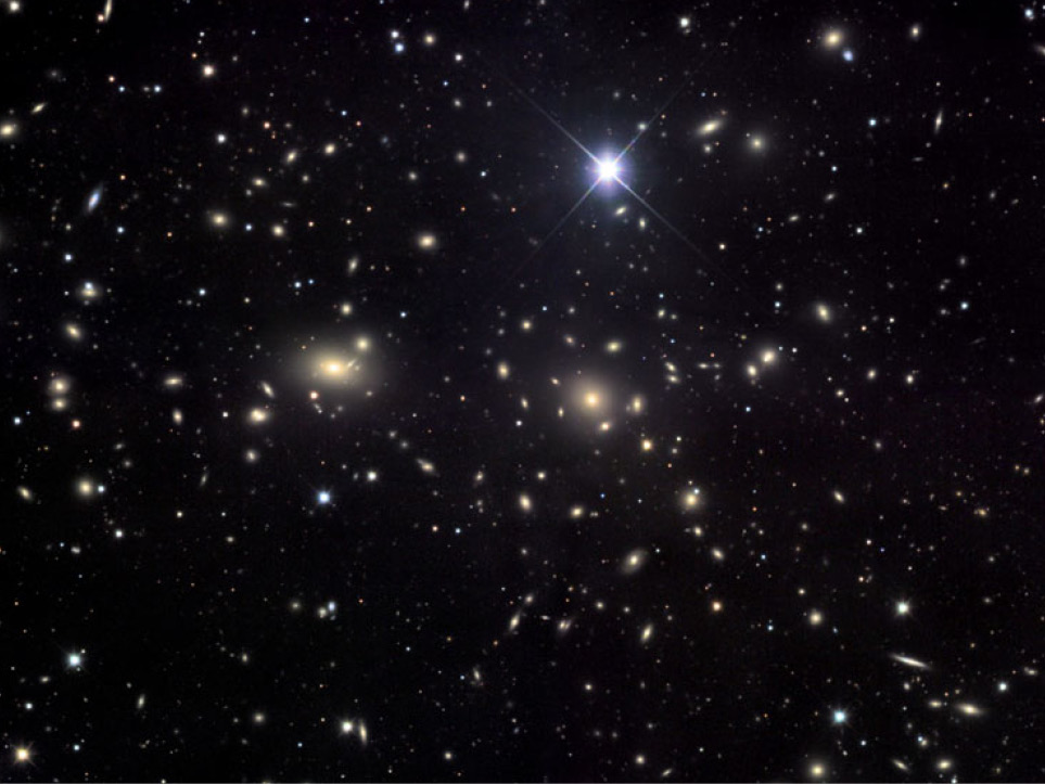 L'astrophysicien Fritz Zwicky était tombé sur une énigme en étudiant l'amas de la Chevelure de Bérénice ou amas de Coma (Abell 1656), un vaste amas de galaxies contenant plus de mille galaxies identifiées et qui se situe à environ 99 mégaparsecs de la Voie lactée. Il devait contenir 400 fois plus de masse que celle observée sous forme lumineuse. Zwicky en parlait déjà comme d'une matière noire. Aujourd'hui, on sait qu'il avait raison bien que la valeur exacte de la masse de matière noire contenue dans l'amas de Coma soit bien plus faible que ne le pensait Zwicky. Les secrets de cette matière noire résident peut-être dans les galaxies naines. © Jim Misti