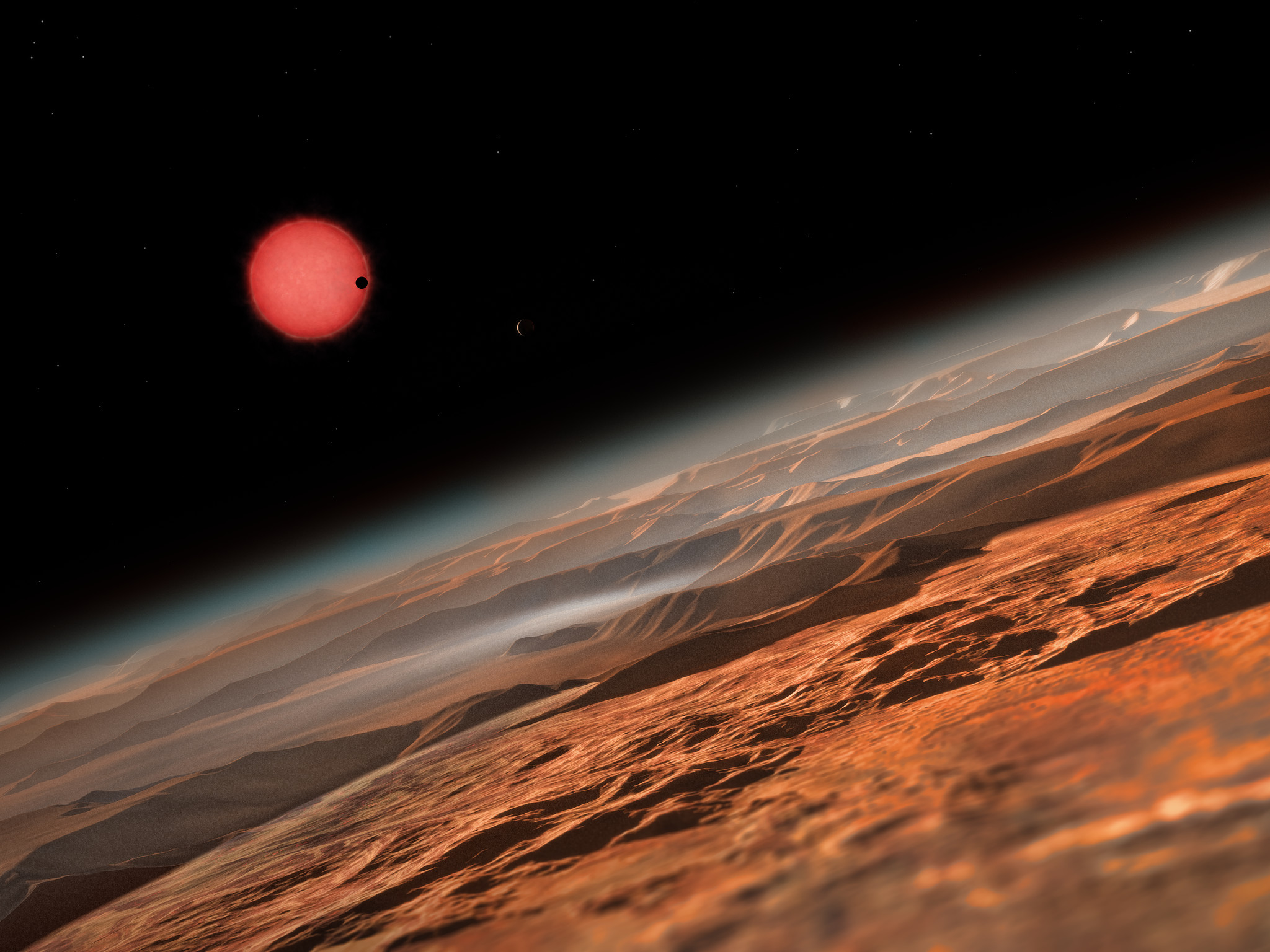 Une vue d’artiste depuis les environs d’une des trois planètes en orbite autour de l'étoile Trappist-1, une naine rouge très froide située à seulement 40 années-lumière de la Terre. Ce sont les premières planètes découvertes autour d’une telle étoile si petite et si peu lumineuse. Sur l'image, l’une des planètes internes passe devant le disque de sa petite et peu lumineuse étoile. © ESO, M. Kornmesser