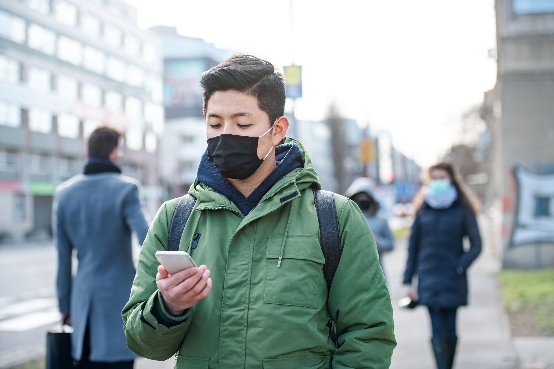 Un homme masqué se balade dans la rue, téléphone en main. ©halfpoint, Envato elements