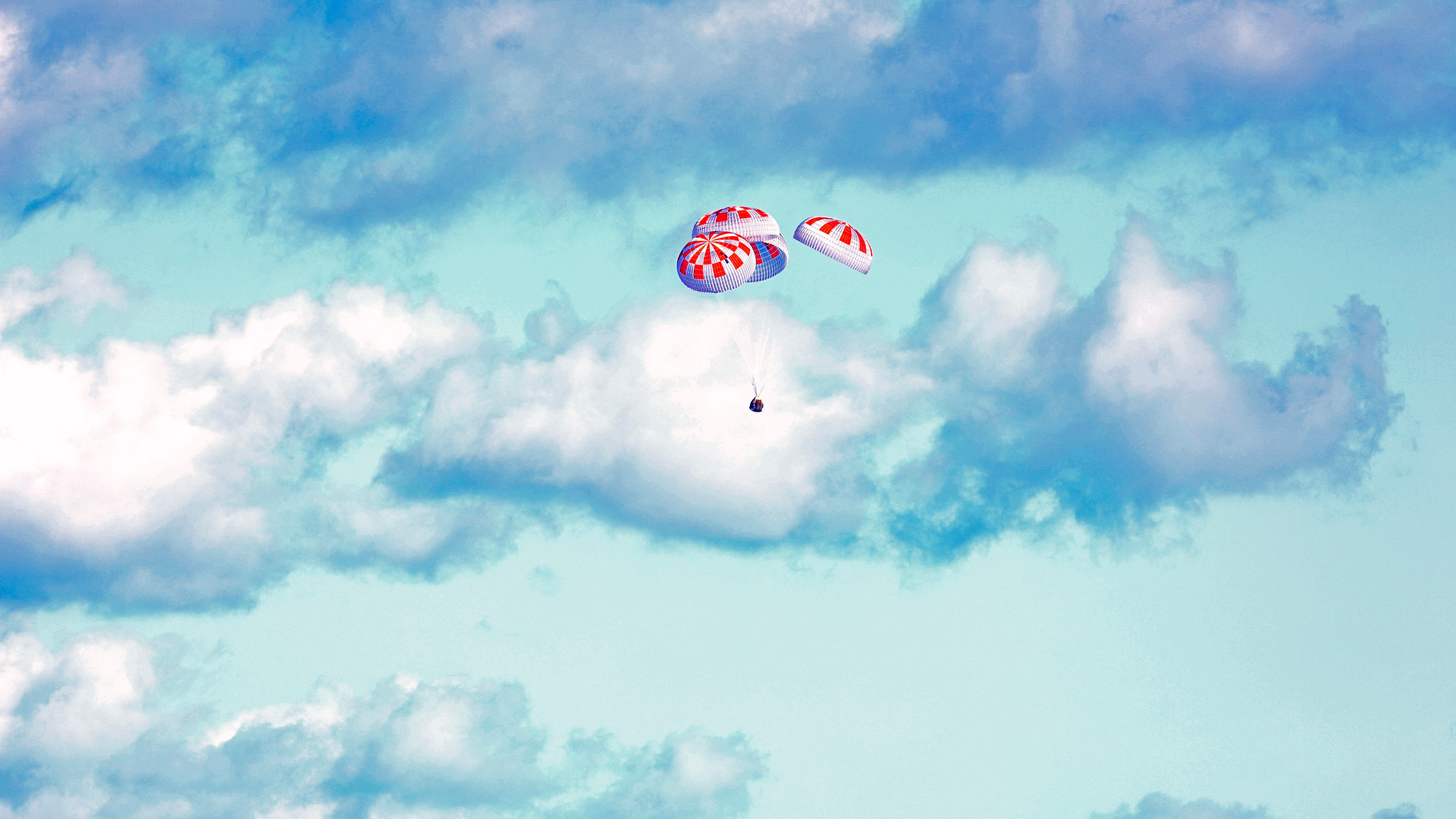 La Crew Dragon et ses quatre immenses parachutes, quelques instants avant son amerrissage sur l'océan Atlantique. © Nasa, Cory Huston 