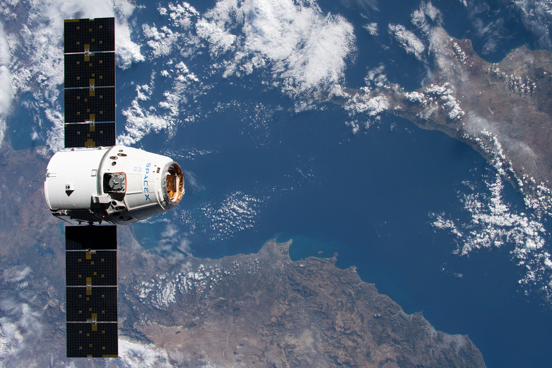 Un véhicule cargo Dragon de SpaceX en vol pour ravitailler la Station spatiale internationale. Toucan Space utilisera ce moyen de transport spatial pour envoyer ses objets et ceux de ses clients à bord de l'ISS. © Nasa