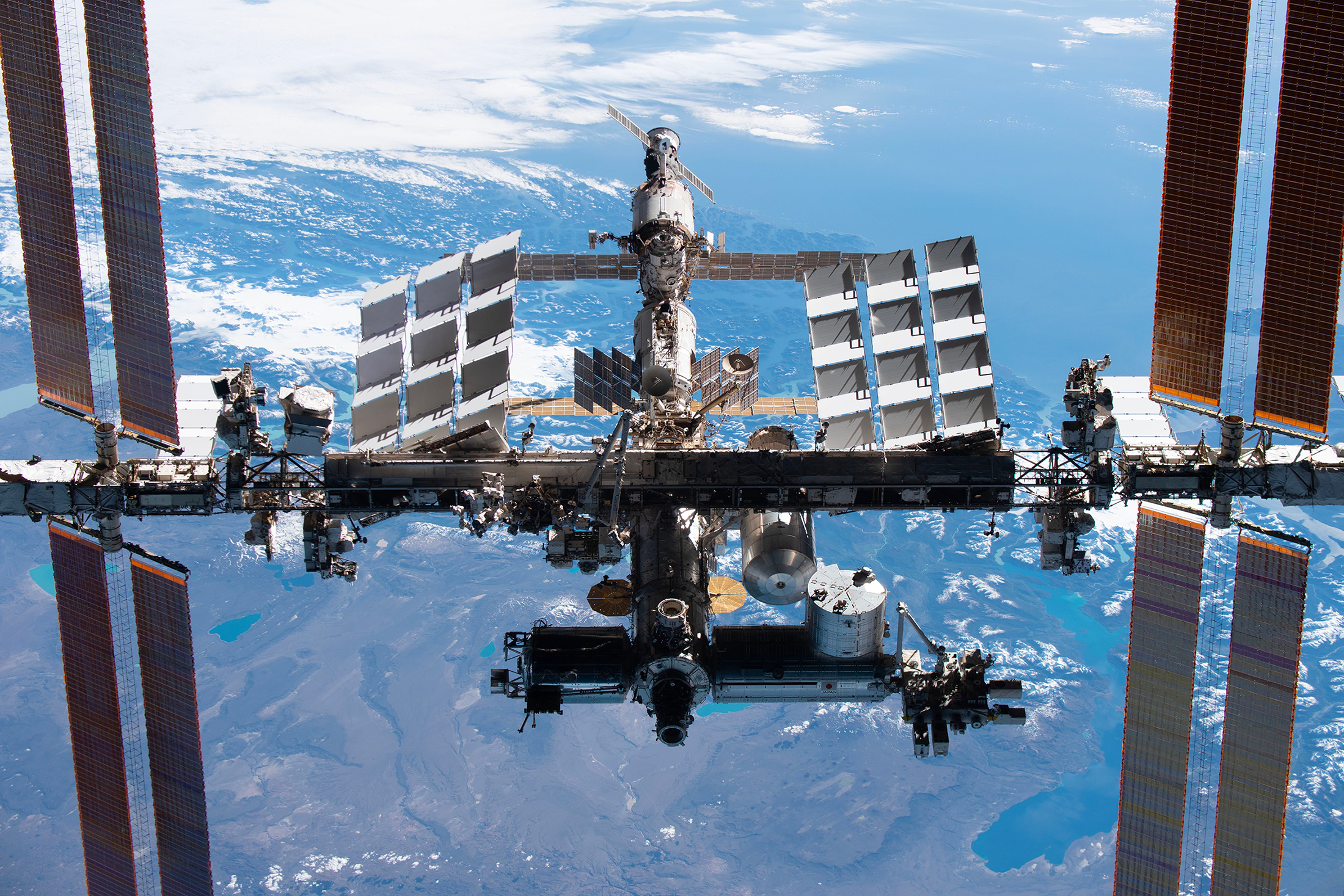 La Station spatiale internationale en novembre 2021, vue depuis la capsule Crew Dragon de SpaceX. Le segment russe se situe en haut de l'image. À l'ombre, la partie occidentale. © Nasa