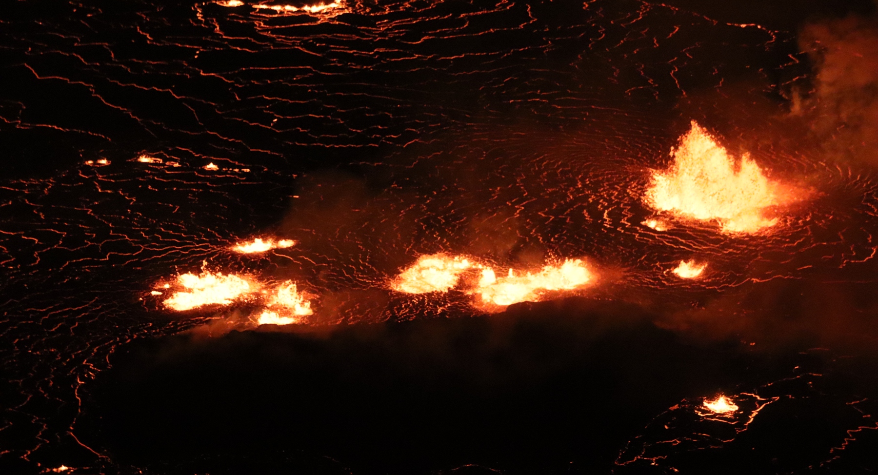 L'éruption en cours du sommet du Kīlauea dans le cratère Halema'uma'u continue d'alimenter les fontaines de lave basses au centre du lac de lave (photo) et le long du mur ouest du cratère Halema'uma'u. Cette image au téléobjectif regarde vers l'est au centre du lac de lave. La zone sombre sous les fontaines est « l'île de lave » qui s'est formée en décembre 2020. © USGS M. Patrick