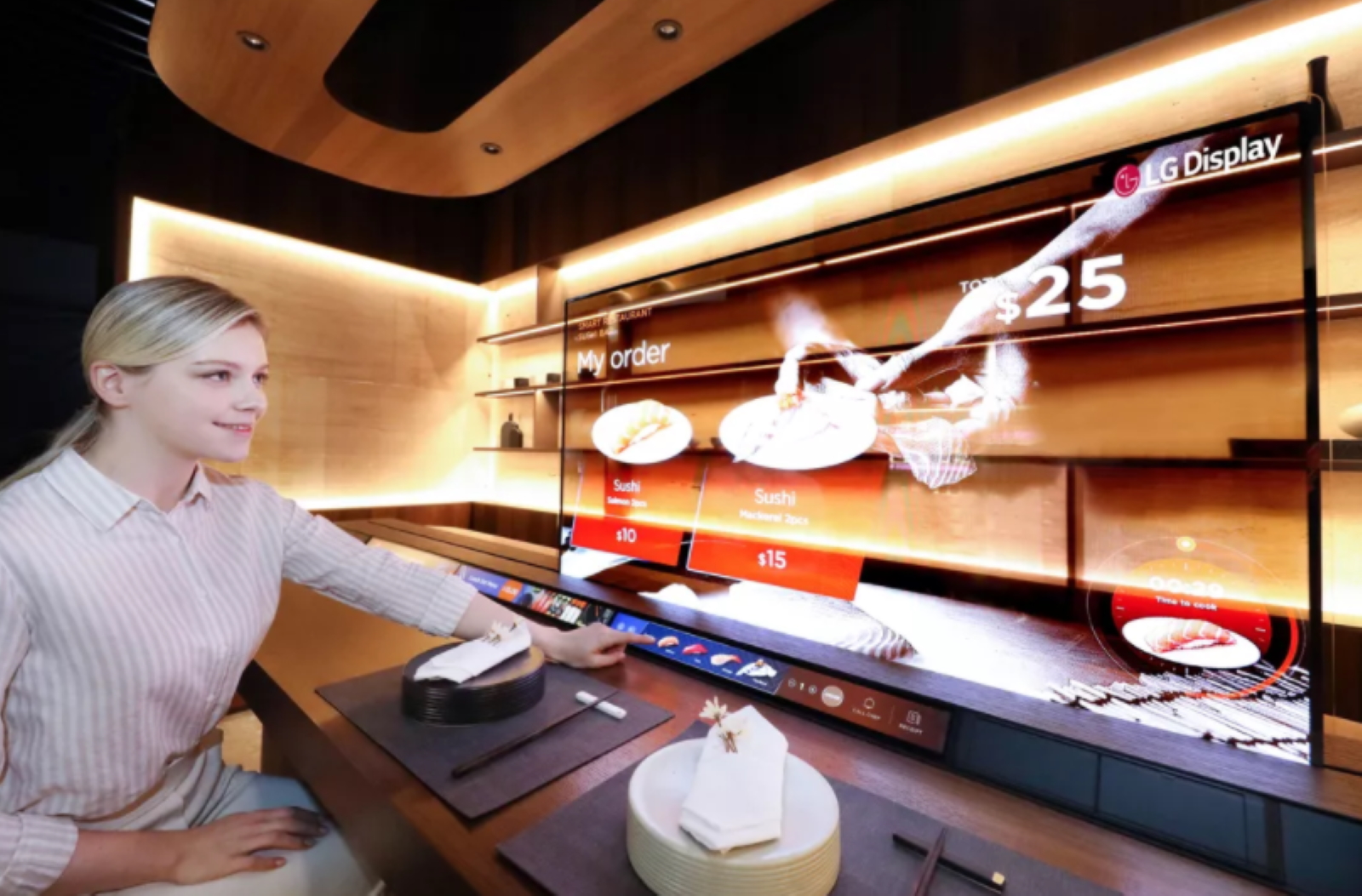 Un bar à sushis dans lequel l’écran permet d’afficher des menus sans pour autant masquer les préparations du chef. © LG