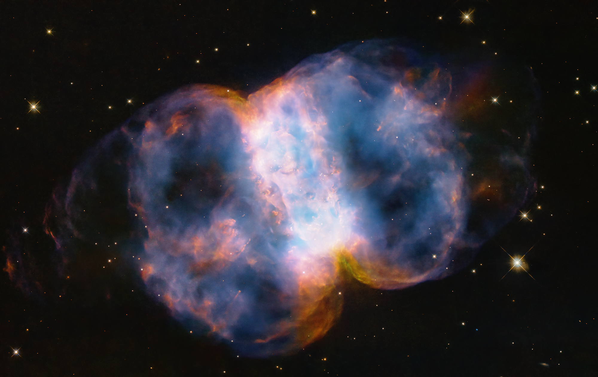 Pour célébrer le 34e anniversaire du lancement du légendaire télescope spatial Hubble de la Nasa, les astronomes ont pris un instantané de la nébuleuse du Petit Haltère, également connue sous le nom de Messier 76, ou M76, située à 3 400 années-lumière dans la constellation circumpolaire nord de Persée. Le nom « Petit haltère » vient de sa forme, qui est une structure à deux lobes de gaz colorés, marbrés et incandescents, ressemblant à un ballon pincé autour d'une taille moyenne. Comme un ballon qui se gonfle, les lobes s'étendent dans l'espace à partir d'une étoile mourante vue comme un point blanc au centre. Le rayonnement ultraviolet fulgurant de l’étoile super chaude fait briller les gaz. La couleur rouge vient de l’azote et le bleu de l’oxygène. © Nasa, ESA, STSc
