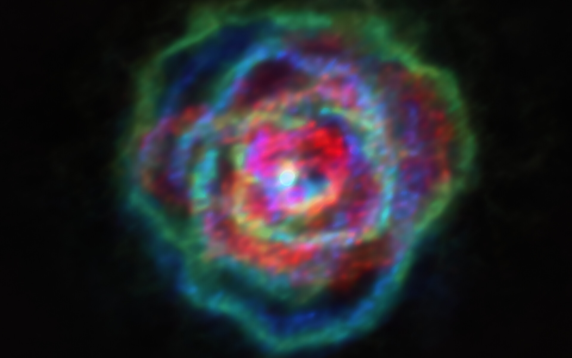 On dirait une nébuleuse planétaire, on dirait une rose aux pétales de différentes couleurs. Il s'agit des vents stellaires de l'étoile R Aquilae. © Alma (ESO, NAOJ, NRAO), Decin et al.