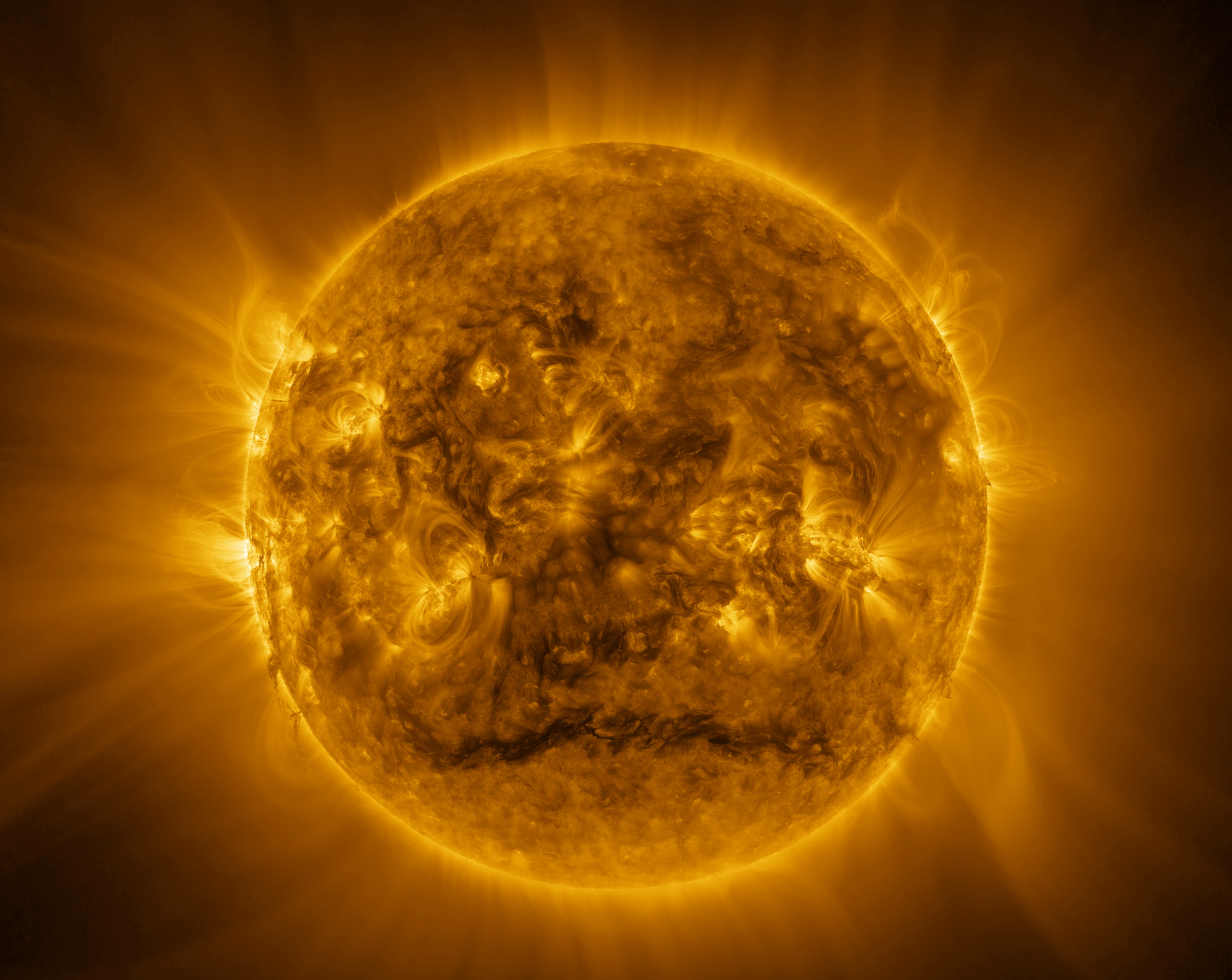Cette grande image a été assemblée à partir d'images prises entre 13 h 06 et 17 h 31 UTC (14 h 06-18 h 31 CET) le 9 mars 2025 par l'imageur ultraviolet extrême de Solar Orbiter, à une longueur d'onde de 17,4 nanomètres. Solar Orbiter observait le Soleil depuis une latitude de 11,4° sous l'équateur, à une distance d'environ 77 millions de kilomètres. L'image finale mesure 12 544 x 12 544 pixels, soit 6 171,6 x 6 171,6 secondes d'arc, soit 2 325,5 x 2 325,5 millions de km. Le Soleil, d'un diamètre de 1,4 million de km, mesure environ 7 505 pixels et 3 692,6 secondes d'arc. Le Soleil ressemble à une sphère jaune chaud dont la surface est recouverte d'une chevelure hirsute et brillante. La lueur jaune s'étend jusqu'aux bords de l'image, certaines zones étant plus lumineuses que d'autres. De nombreux arcs jaune vif se détachent d'une large bande autour de l'équateur solaire. Une zone plus sombre se détache sur une ligne à peu près horizontale près du pôle Sud. Les arcs lumineux et quelques particules plus sombres sont également visibles sur les bords du Soleil. © ESA &amp; Nasa, Solar Orbiter, EUI Team, E. Kraaikamp (ROB) 