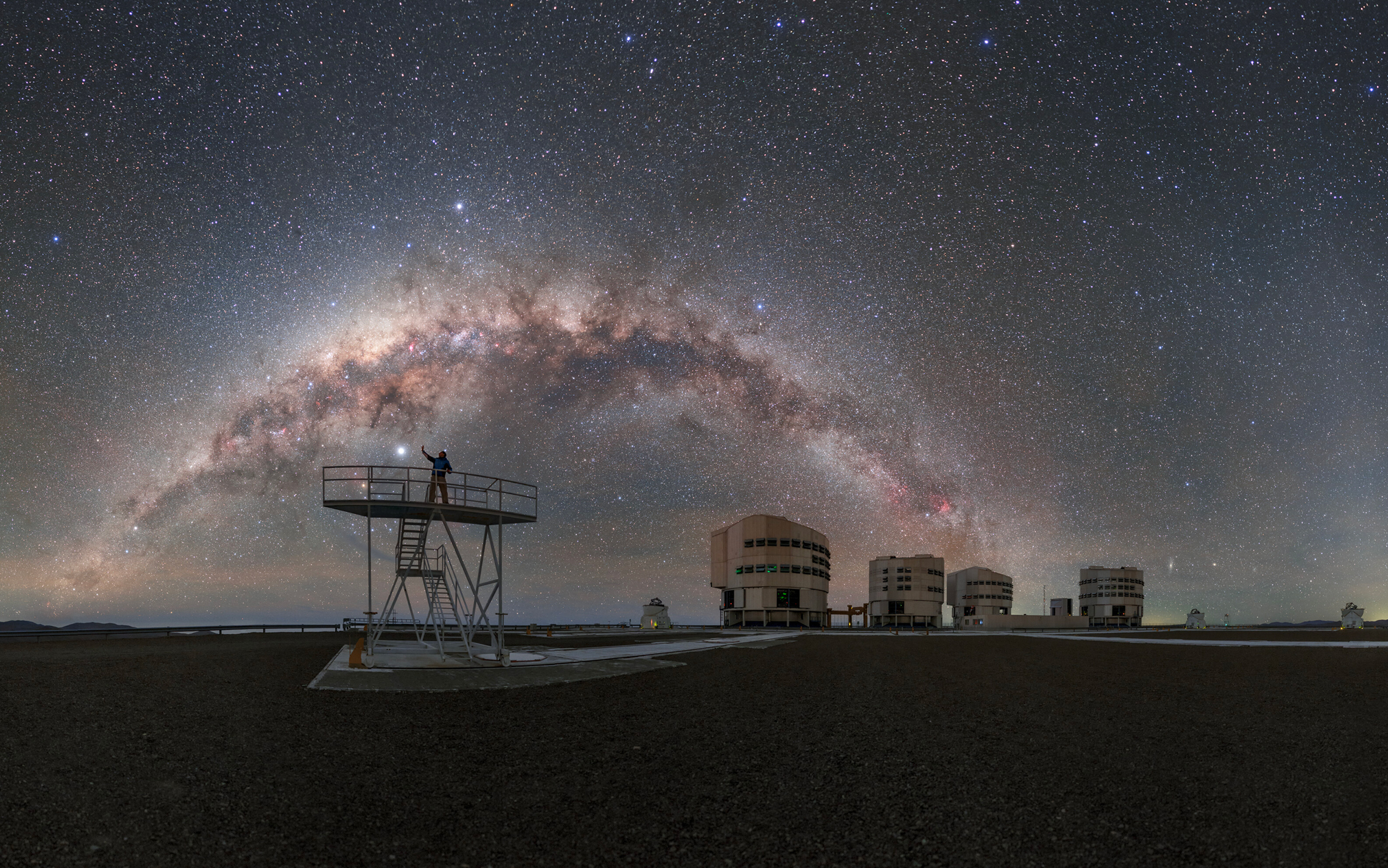 Cette photo a été prise depuis l'observatoire Paranal de l'ESO. Abritant le Very Large Telescope (VLT), l'observatoire se trouve au sommet du Cerro Paranal, à 2 635 mètres d'altitude, dans le désert d'Atacama, au nord du Chili. Sur cette image, la Voie lactée apparaît presque comme un arc-en-ciel fait d'étoiles, s'arquant au-dessus du site. © ESO