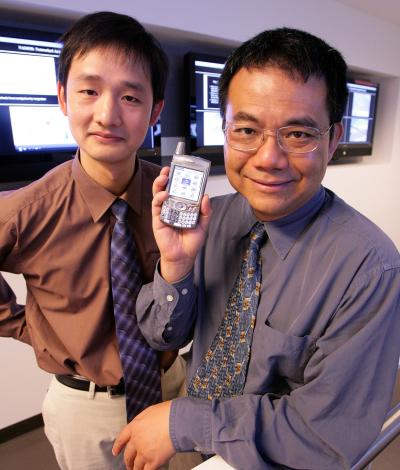 Yang Yang, à droite, et Jinsong Huang, à gauche, montrent un téléphone mobile. Ils en sont sûrs : dans peu de temps, les fabricants de ce genre d’appareils se seront convertis aux écrans Pled. Crédit : UCLA Engineering/R. Hutchinson