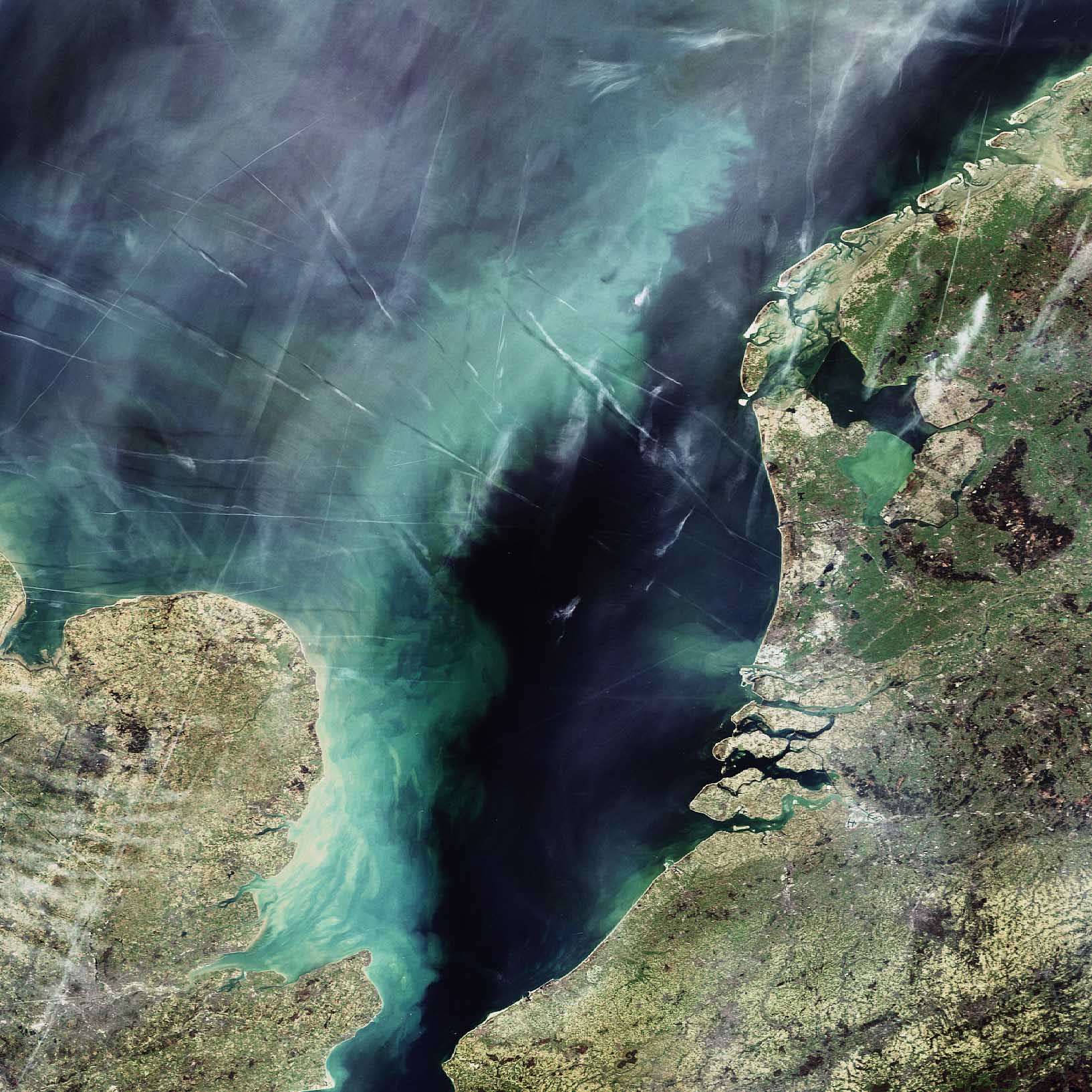 La Mer du Nord vue par Envisat. On y voit une partie des Pays-Bas (à droite), de la Belgique (en bas à droite) et de l’Angleterre (en bas à gauche). Elle laisse également apparaître de nombreuses traînées de condensation laissées par des avions. Crédit Esa/Envisat