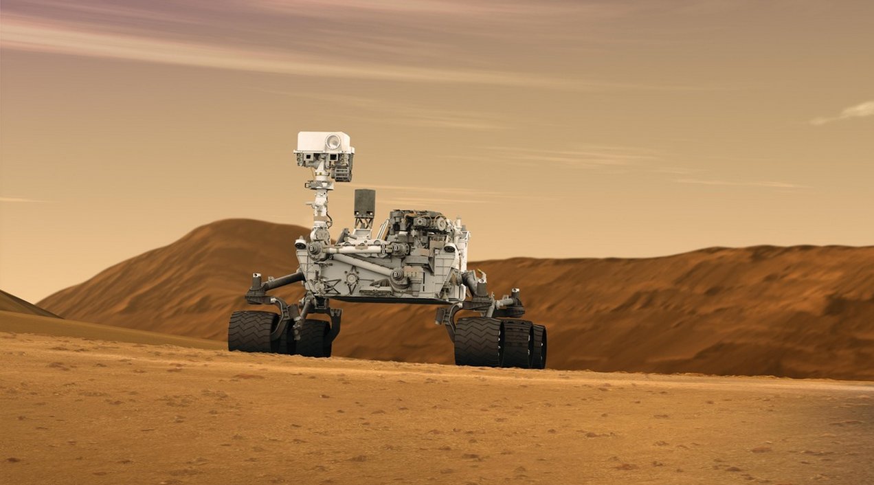 Le rover Curiosity (une vue d'artiste, bien sûr), tel qu'il doit se présenter actuellement, sur la planète Mars. Le mât est levé, ou va le faire, pour commencer à inspecter les alentours.&nbsp;© JPL,&nbsp;Caltech