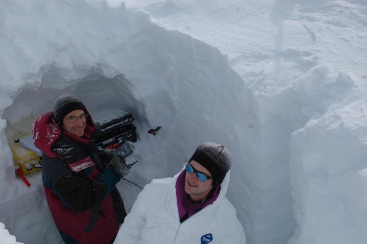 Florent Domine et Samuel Morin effectuent des mesures physiques et des échantillonnages de neige dans un puits creusé dans un glacier du Spitzberg. © LGGE