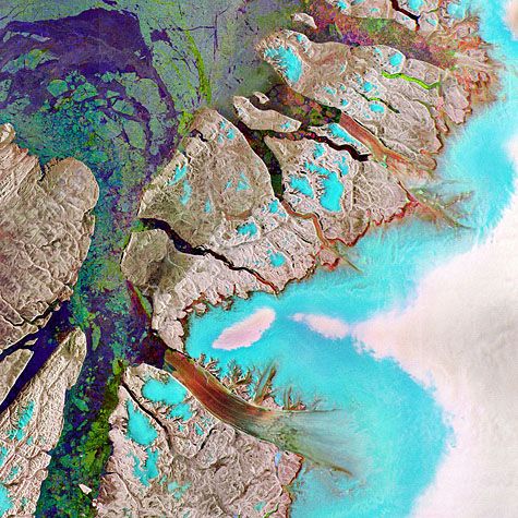 Les fausses couleurs indiquent la nature du sol. Le bleu et le blanc correspondent à la couverture de glace du Groenland.  De teinte rougeâtre sur cette image, le glacier Petermann flotte sur la mer et s'écoule dans le détroit de Nares, ici en vert en en bleu-violet. Crédit : Esa