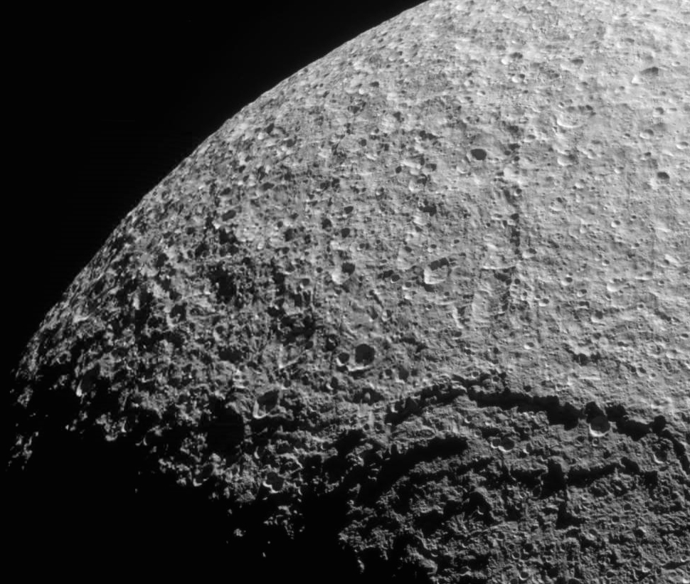 Vue de la surface cratérisée du satellite Téthys. On distingue le bord du cratère Odyssée, résultat d'un violent impact qui s'est produit dans la jeunesse du satellite. © Nasa/JPL/Space Science Institute