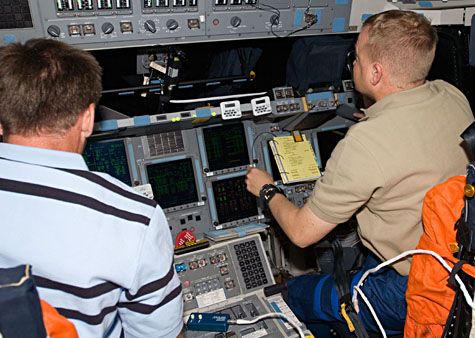 Le commandant de bord Chris Ferguson (gauche) et le pilote Eric Boe (droite) préparent Endeavour aux manœuvres d'approche et d'amarrage de la navette. Crédit Nasa