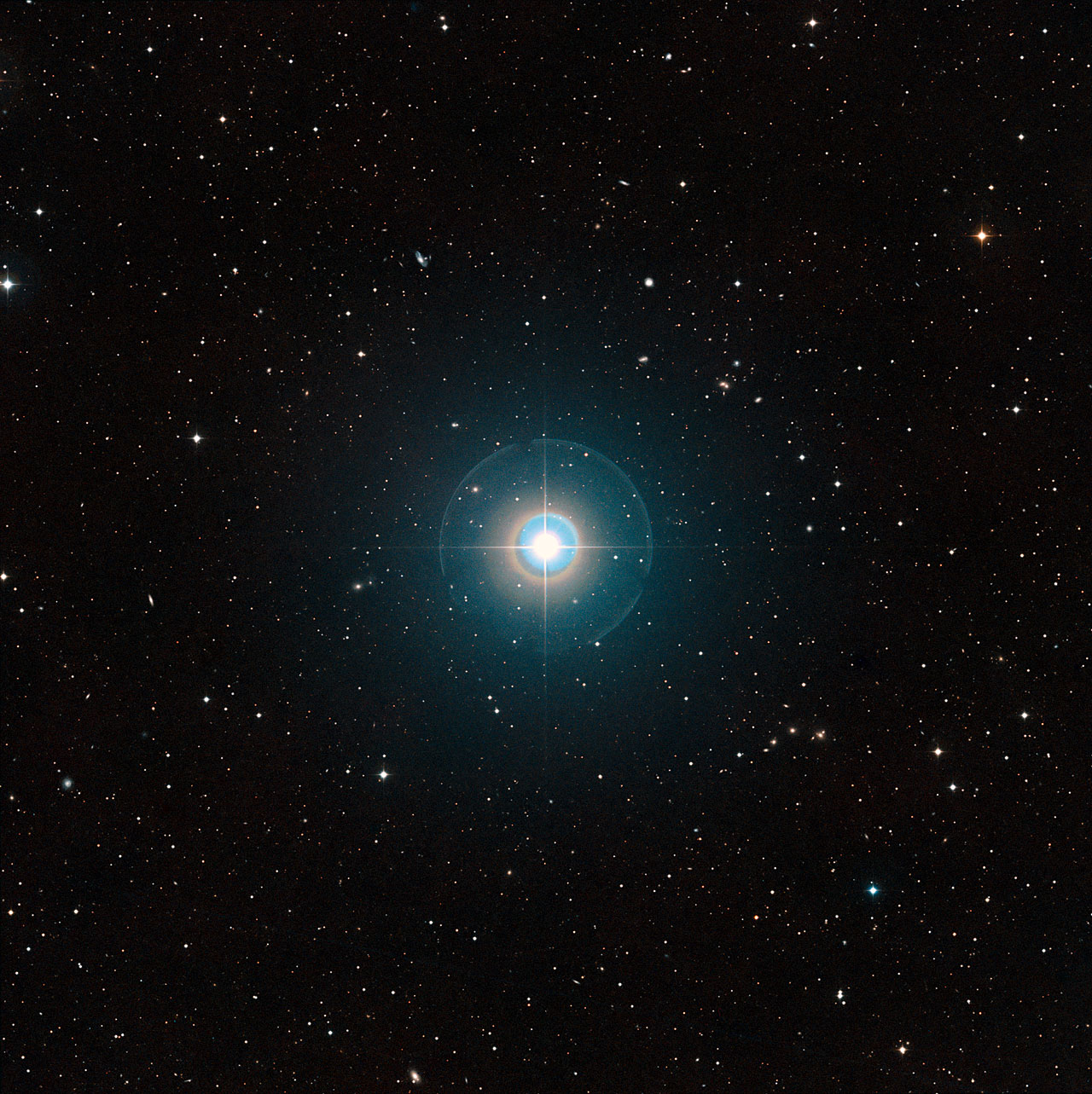Cette image à grand champ du ciel autour de Tau Bootis a été créée à partir de clichés du Digitized Sky Survey 2. L'étoile elle-même, suffisamment brillante pour être vue à l'œil nu, se trouve au centre. Les traits fins et les cercles colorés autour d'elle sont des artefacts provoqués par le télescope et la plaque photographique utilisée et ne sont pas réels. L'exoplanète Tau Bootis b est en orbite à faible distance de l'étoile et est totalement invisible sur cette image. La planète vient juste d'être détectée de manière directe grâce à sa propre lumière en utilisant le VLT de l'ESO. © ESO/Digitized Sky Survey 2