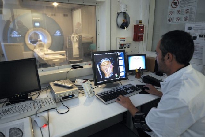 Un médecin observe les images d'un cerveau obtenues à partir d'une IRM. © AFP Photo, Anne-Christine Poujoulat
