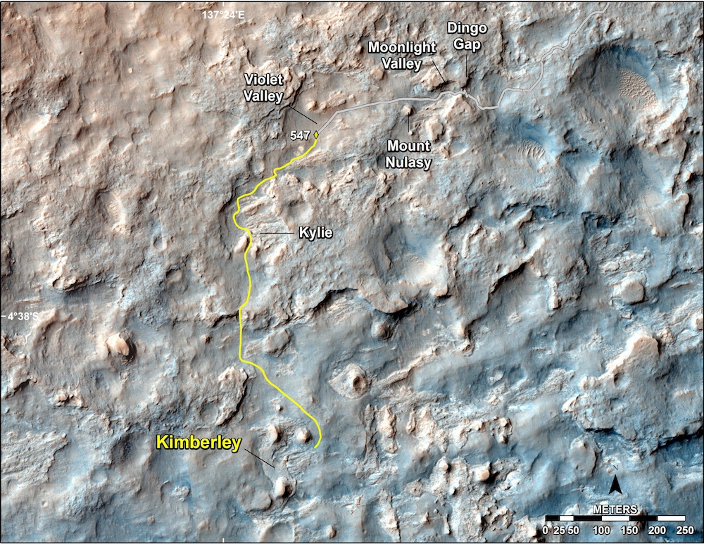 Sur cette image de la caméra HiRise (High Resolution Imaging Science Experiment) de la sonde spatiale Mars Reconnaissance Orbiter (MRO), on découvre le contexte topographique où progresse actuellement Curiosity. La dune Dingo Gap fut franchie lors de son 535e jour sur Mars (sol 535). Depuis, le rover emprunte un nouvel itinéraire, moins périlleux, et roule à reculons en direction du site Kimberley, distant de 1,1 kilomètre. Le 18 février, il a parcouru plus de 100 mètres en une seule journée. © Nasa, JPL-Caltech, université d’État de l’Arizona