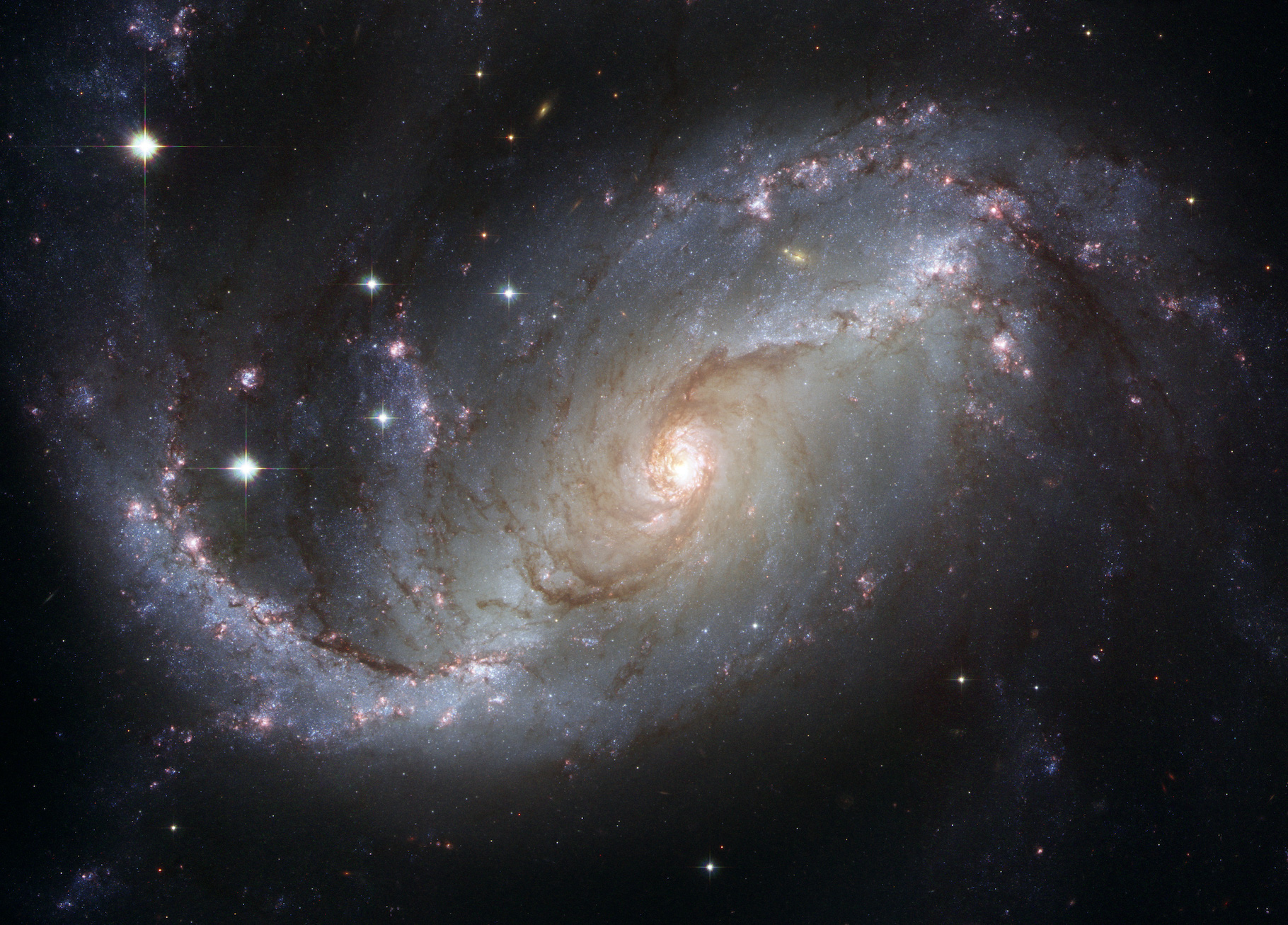 Cette image composite de la galaxie spirale barrée NGC 1672 a été réalisée en utilisant des filtres qui isolent la lumière des parties bleues, vertes et infrarouges du spectre ainsi que l’émission de l’hydrogène ionisé. © Nasa, ESA, The Hubble Heritage Team (STScI/AURA)-ESA, Hubble Collaboration