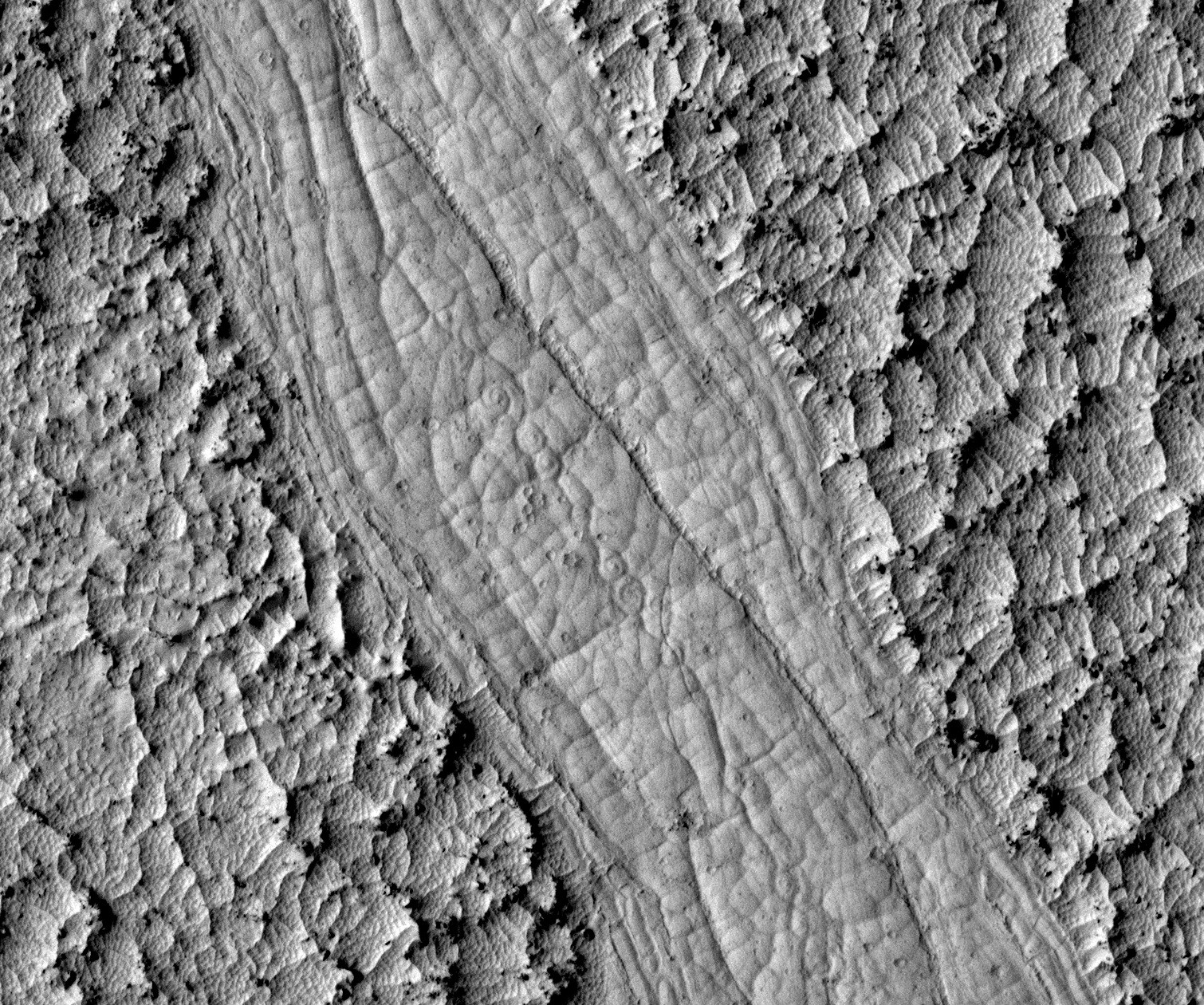 Les spirales découvertes au fond des chenaux d'Athabasca Valles confirment l'origine volcanique de ces écoulements martiens. © Nasa