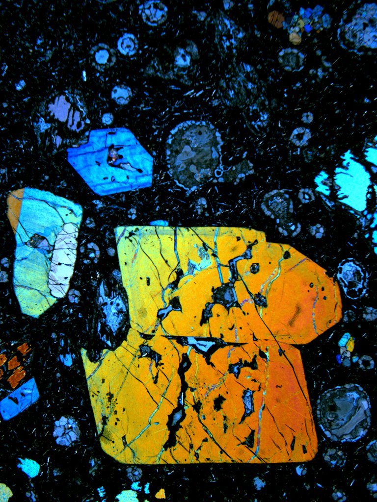 Des composés soufrés présents dans ce cristal d'olivine ont fourni de précieuses informations sur le recyclage des croûtes océaniques archéennes, donc vieilles de plus de 2,45 milliards d'années. La surface réelle du détail du cristal à l’image est de 8,5 mm de haut et de 7 mm de large.&nbsp;©&nbsp;J.M.D. Day