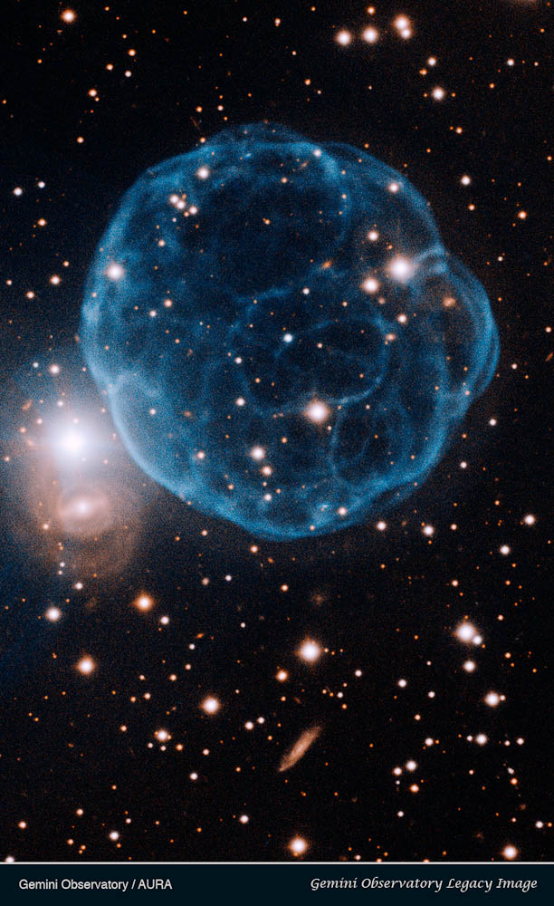 Kronberger 61 est une coquille de gaz ionisé qui ressemble à un ballon de football. La naine blanche qui en est à l'origine est l'étoile bleue près du centre. © Gemini Observatory/Aura